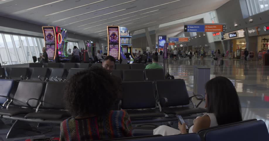A man with glasses sitting in a terminal using a tablet