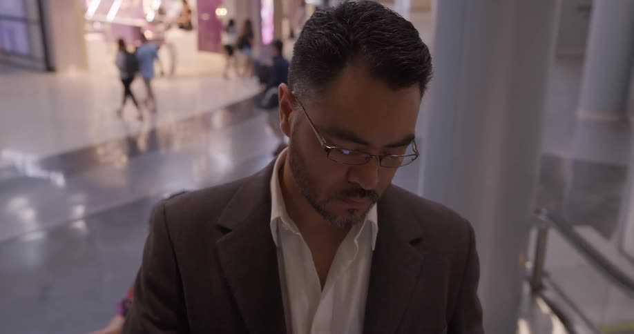 A man rides an escalator to a higher floor in an airport