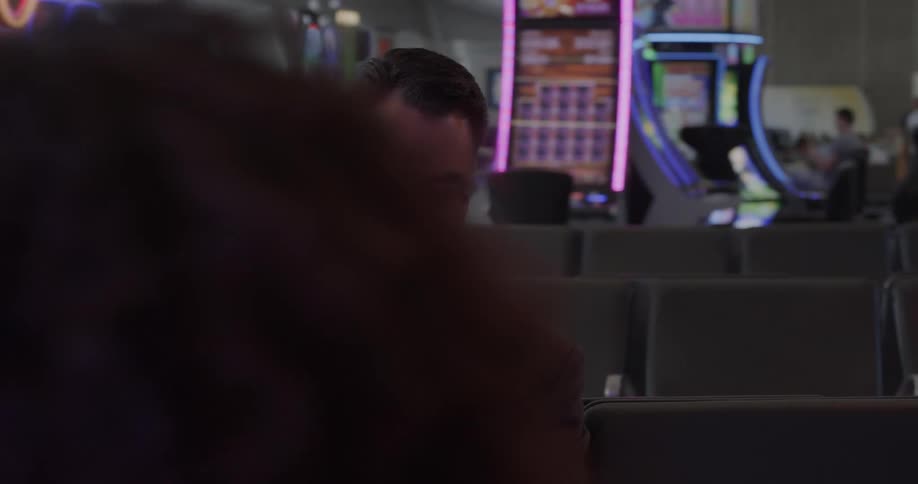 A man with glasses sitting in a terminal using a tablet
