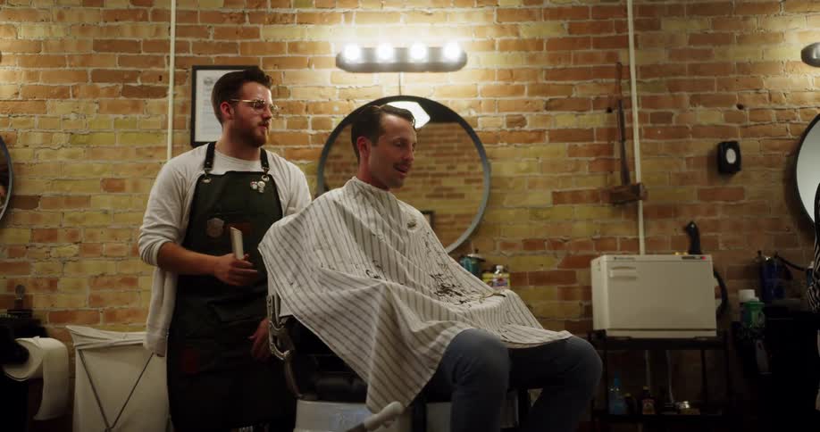 Barber spins a customer on a chair in a barber shop