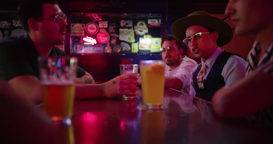 Friends talking and drinking beer at a bar table
