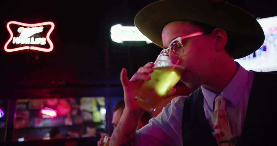 A group of friends toast at a bar counter and drink alcohol
