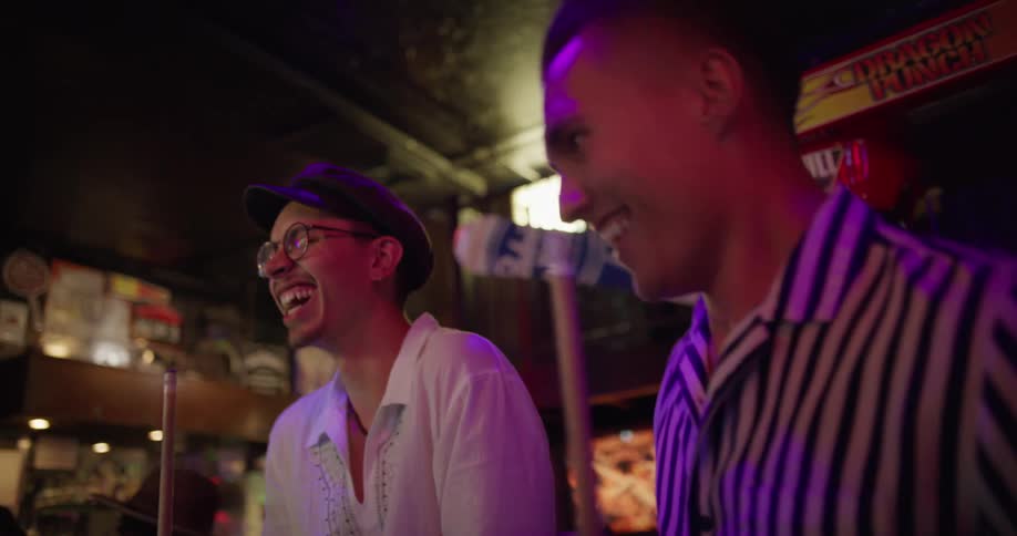 Two man dance in a bar with pool sticks