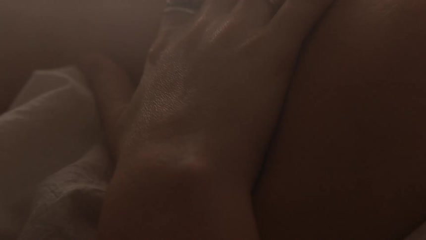 Close up of a person rubbing its arm while laying in bed
