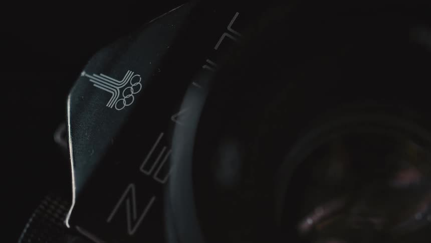 A camera lens with letters and a reflection