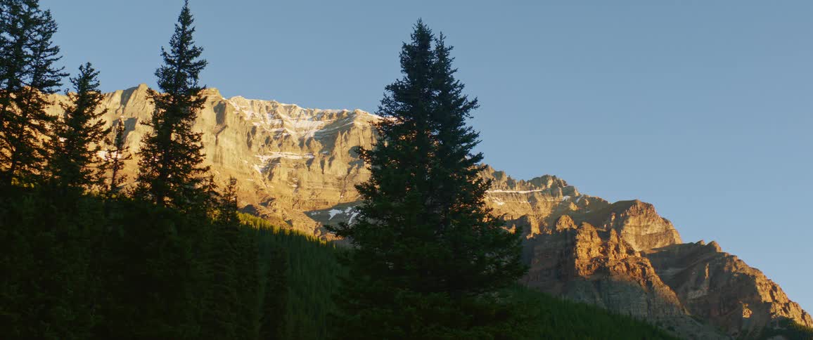 The sun is setting above the mountains
