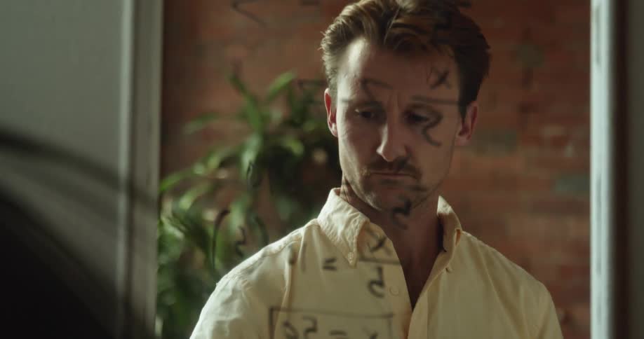 A man writes a formula on a mirror at home