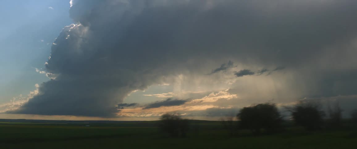 Storm clouds floating above a rural field at sunset