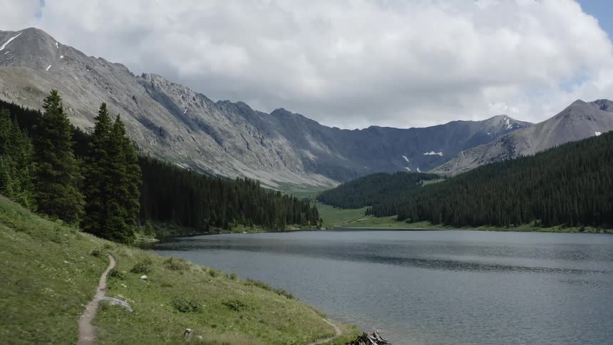 A large lake is surrounded by forests and