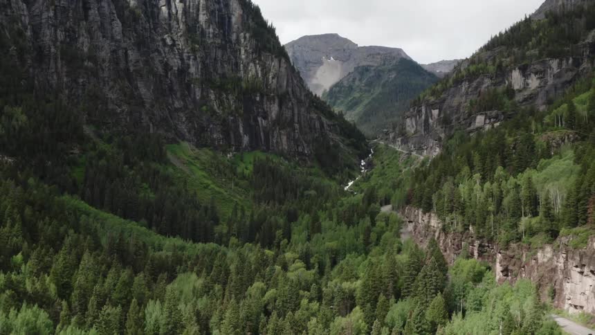 A valley covered in forest between mountain ridges on a cloudy day