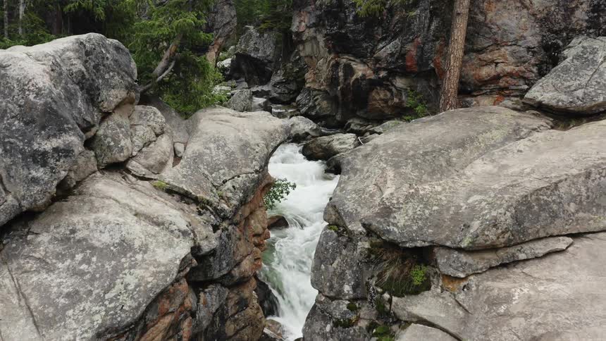 Aerial view of a river flowing on a narrow canyong through the mountain