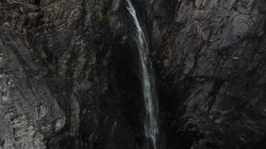Waterfall in the mountains while snow is falling