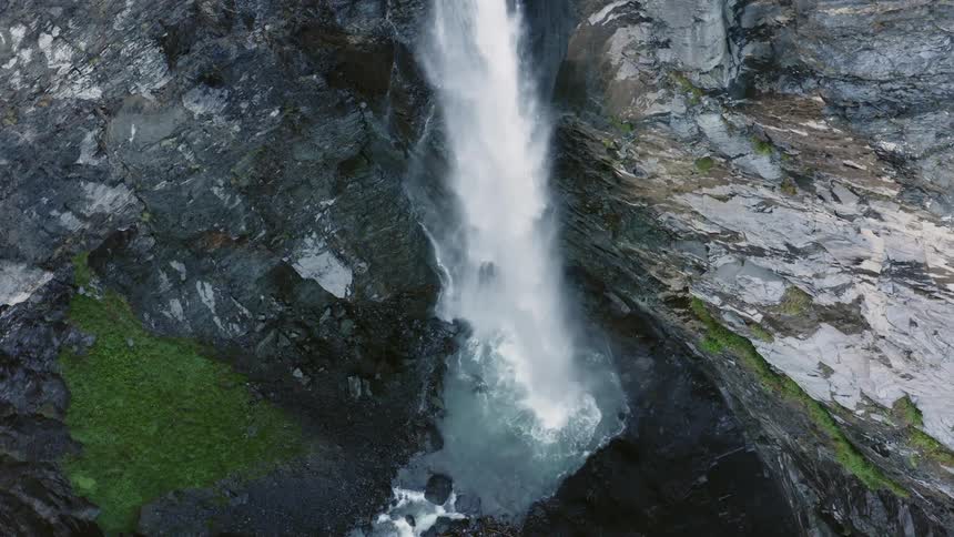 A cliff with a waterfall and algae