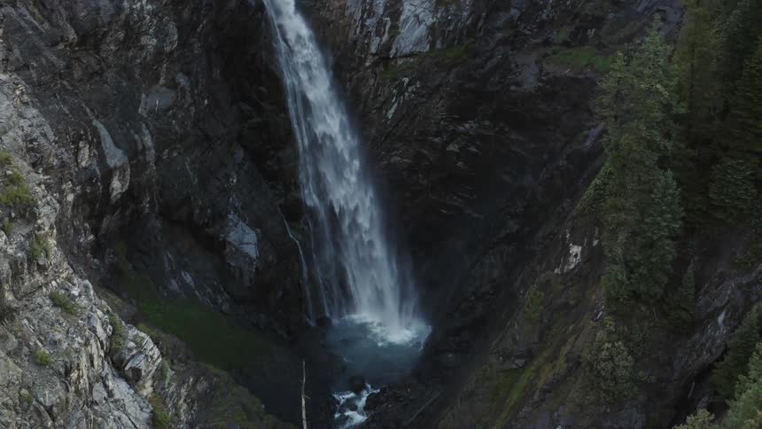 A waterfall and crevasse with moss covering the sides of the rock