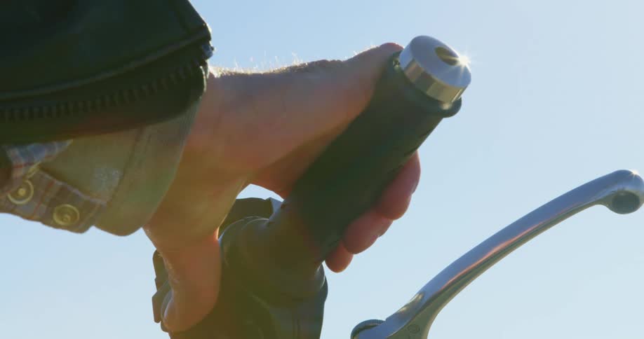 Person wearing jacket and long sleeves grips handlebar