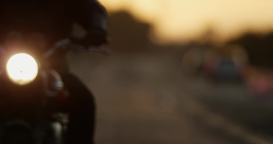 Vehicles are driving on a road at dusk