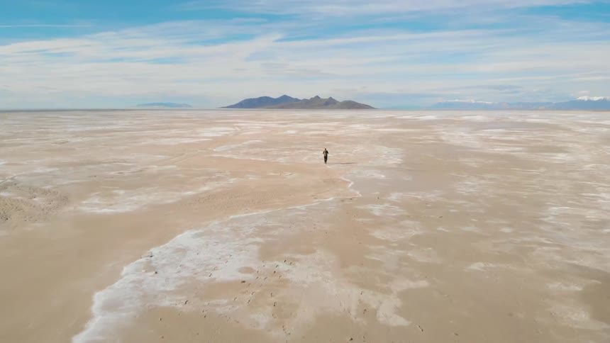 Someone walking alone on a beach on a cloudy day