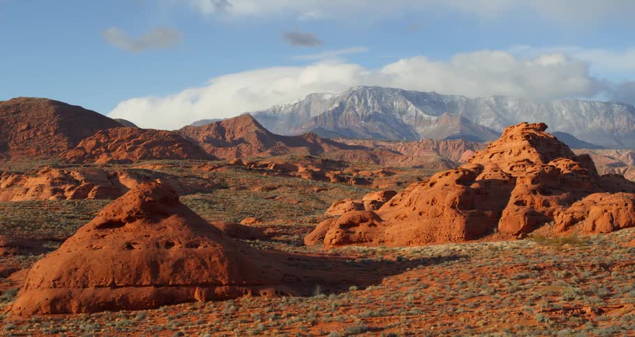 Red rock formations with a snowy mountain in the distance in nature