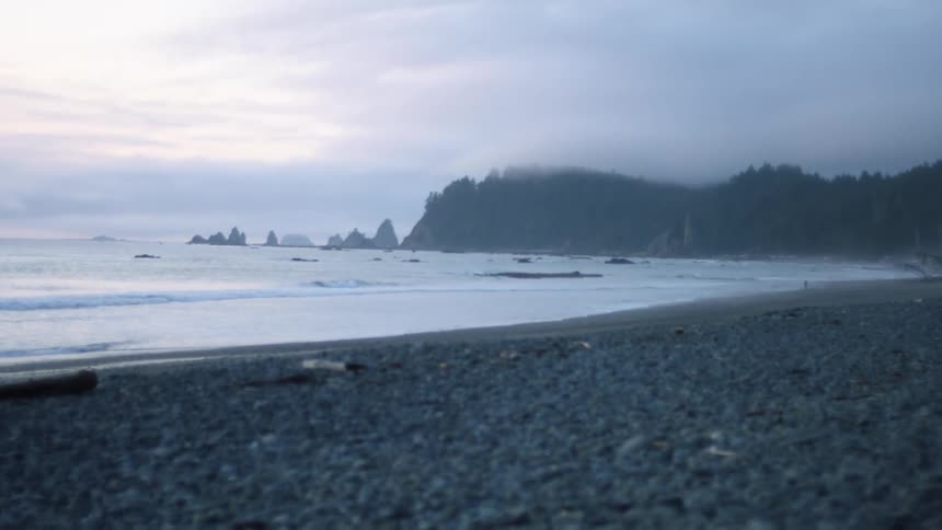 Ocean waves roll into the beach at dusk