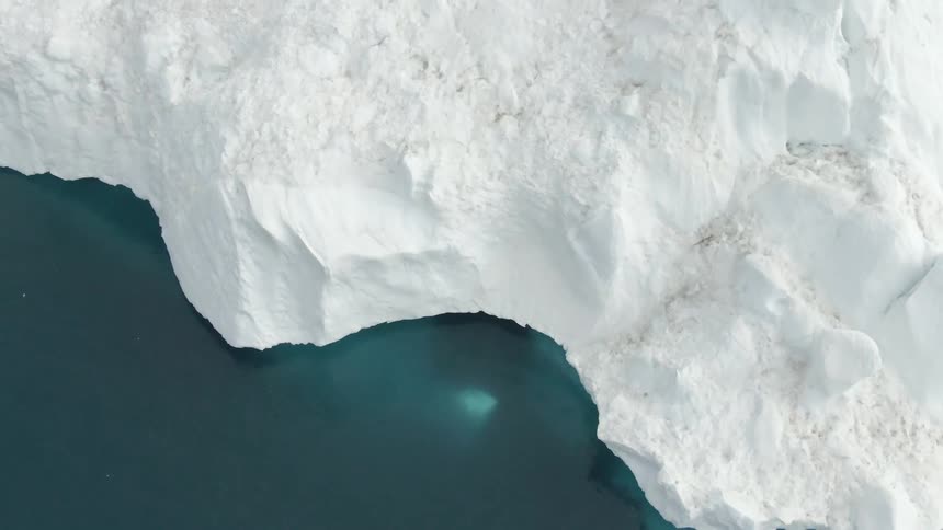 White glacier contrasts with the greenish blue of the ocean