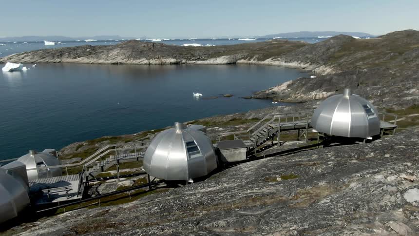 A coast with domes and water with the sky and clouds in the background