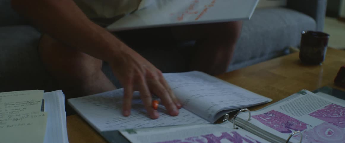 Man sitting on couch working on chemistry formulas and homework