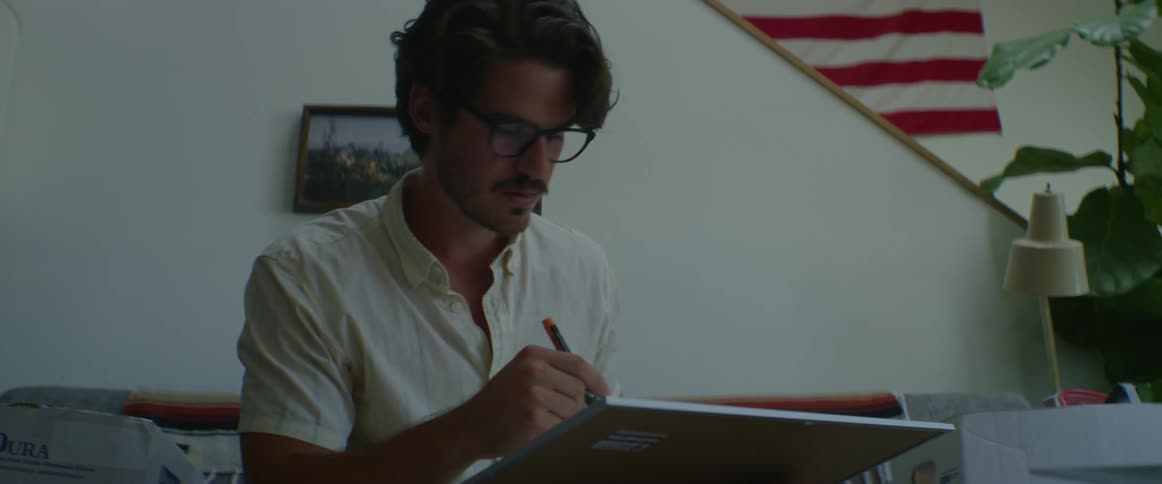 A man uses a marker and draws on a large sketchpad