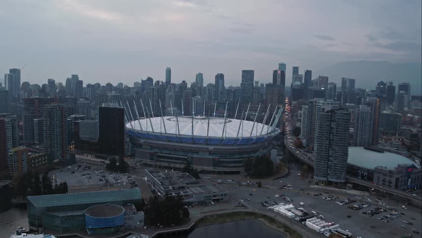 An aerial view of Vancouver's stadium surrounded by skyscrapers in a city