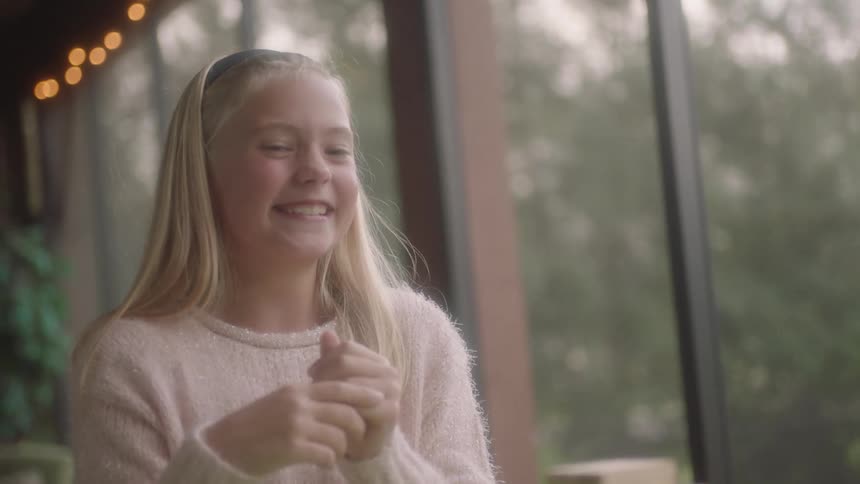 A young girl laughs as she play games at home