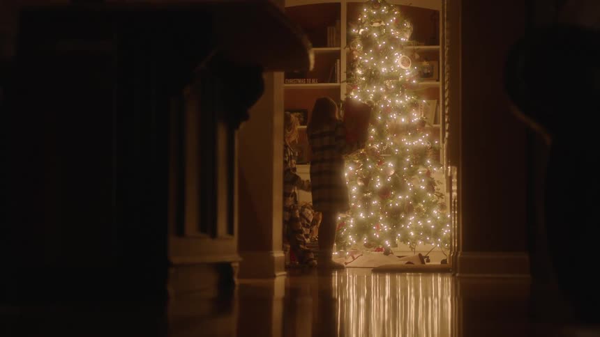 Children check their gifts under the christmas tree