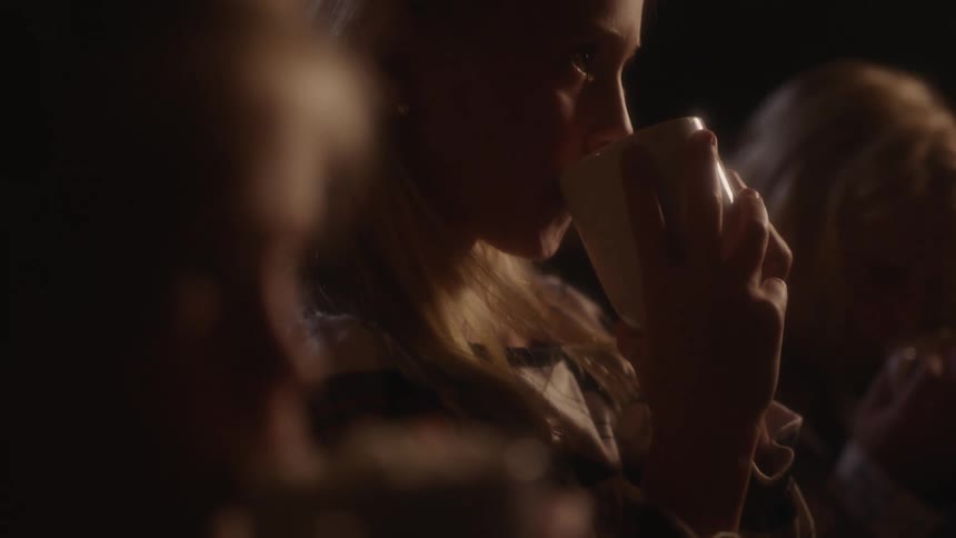 A group of women sip drinks from coffee cups