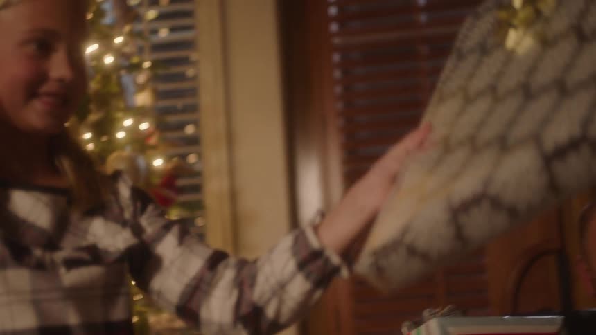 Young girl giving gifts with her family on christmas