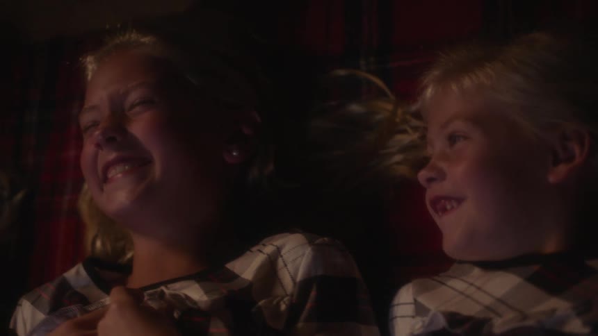 A group of children in pajamas laugh and bond
