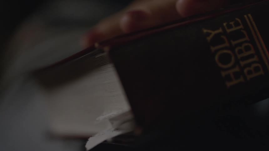 Hand of a person holding a holy bible