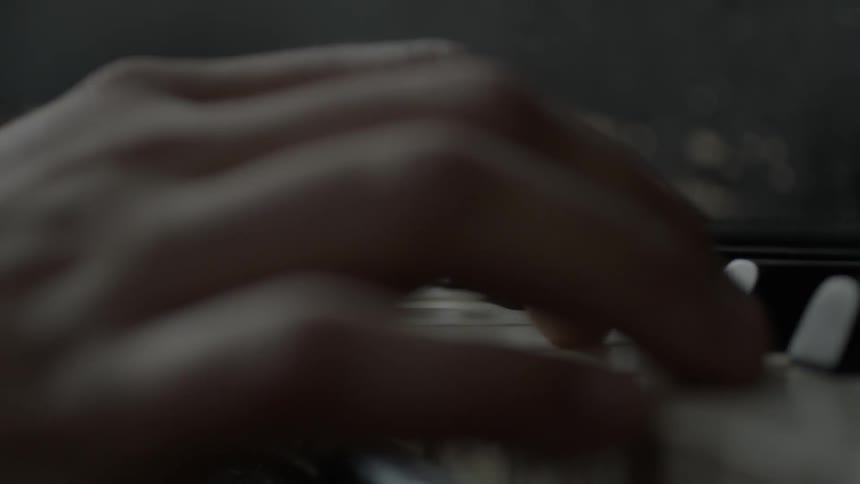 Close up of a hand playing keys on a piano