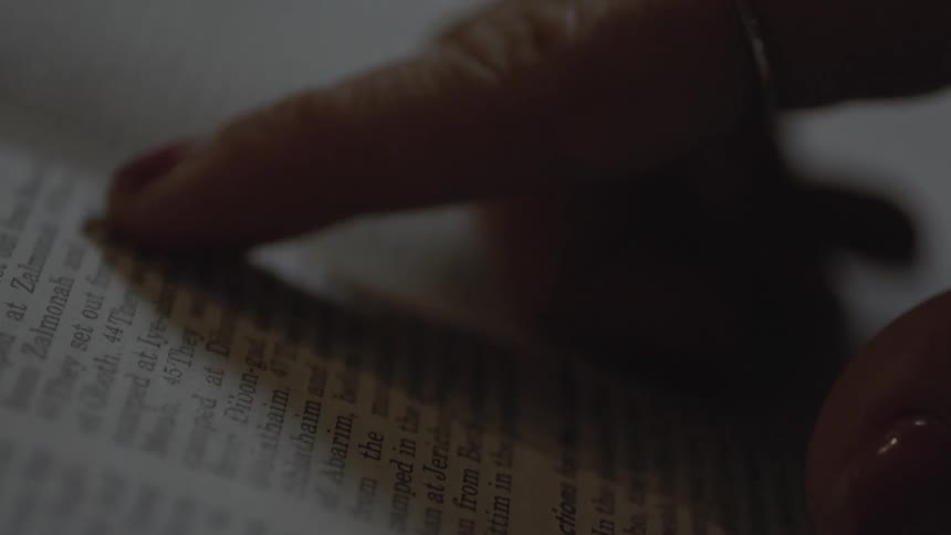 A finger is tracing lines in a book
