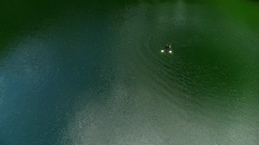 Man swimming out in open water surrounded by wetlands connecting to a river