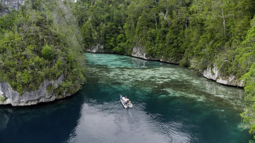 A boat is on a river in a ravine in daylight