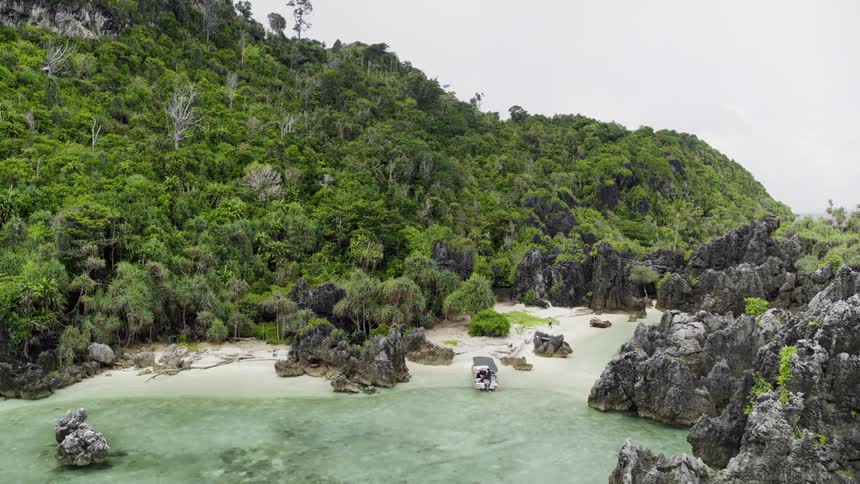 A small boat sits on the beach on an island