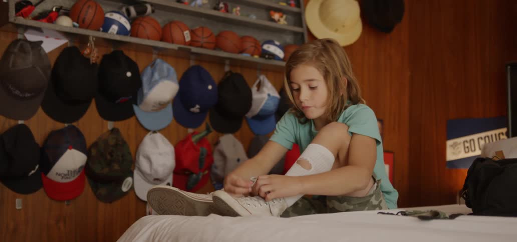 A girl ties her shoes while sitting