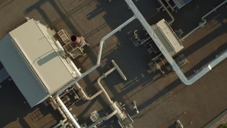 Top down view of pipes and buildings at a natural gas pipeline compressor station