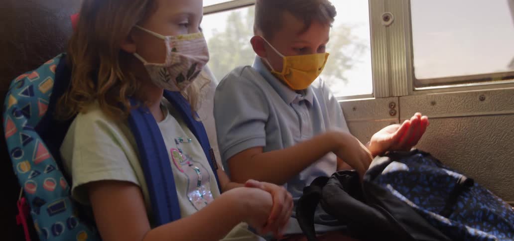 Children using hand gel inside a bus