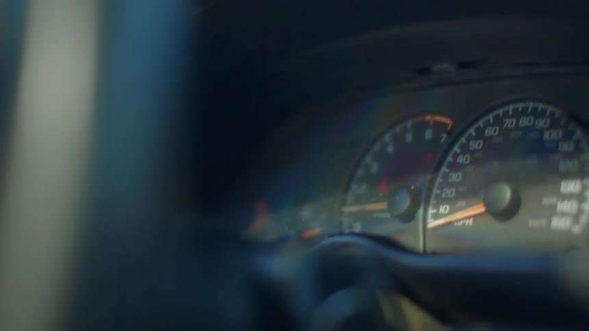 Meters on the dashboard of a vehicle being driving by a person during the day