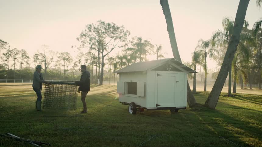 Couple moving something across a farm