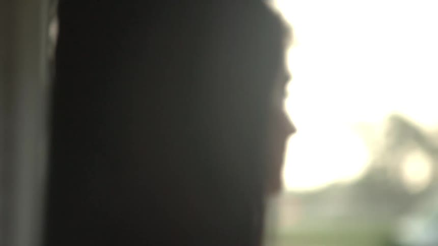 A woman watches the rain outside