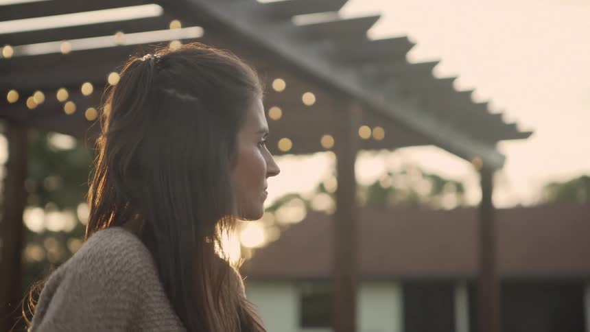 A woman in her yard looking around