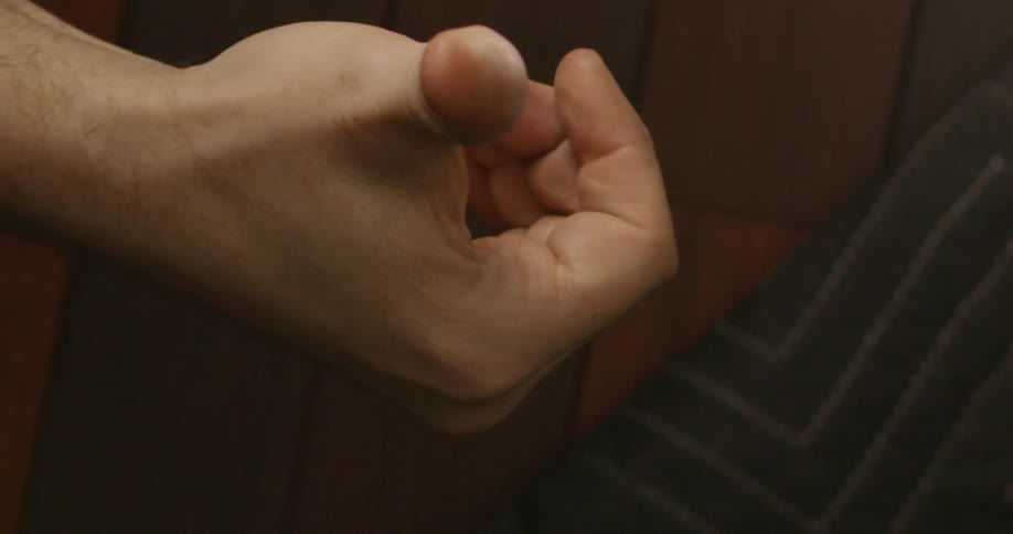 A man flips a quarter with his right hand