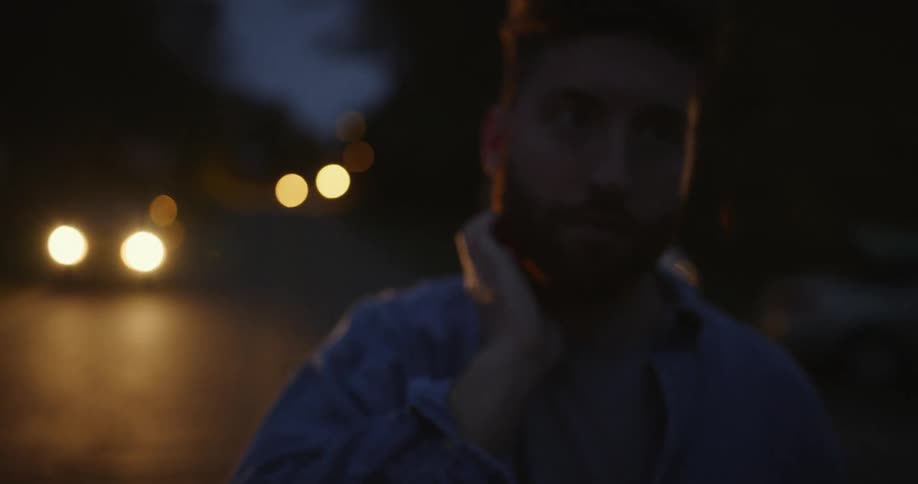 A man is standing outdoors at night