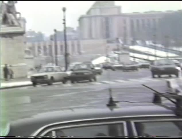 A street in a city during the day in winter with traffic cars buses and pedestrians