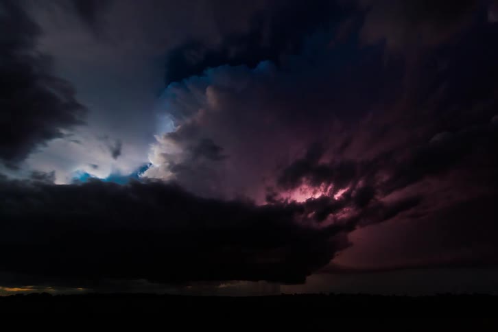 Rolling storm clouds on a dark horizon with flashing lightning